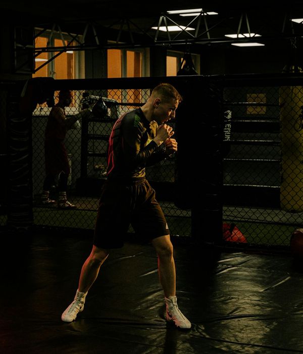 Man performing a strength exercise in a dark, focused environment.